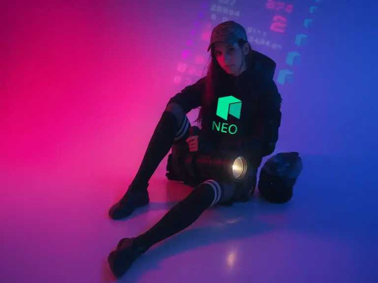 Woman in cyberpunk outfit sitting in neon-lit room, wearing a black hoodie with glowing green NEO logo – crypto streetwear aesthetic