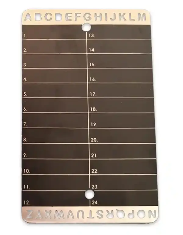 Steel seed phrase backup plate with engraved A–Z and 1–24 grid – shown next to engraving tool